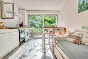 a kitchen and living room with a couch and a table at Gite L'oiseau Du Paradis in Ribérac