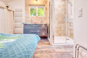 a bathroom with a shower and a bed and a sink at Gite L'oiseau Du Paradis in Ribérac