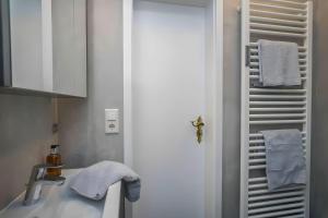 a bathroom with a sink and a towel rack at Tolle Wohnung mit Sonnenbalkon in Wenningstedt +29 photos