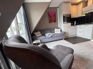 a living room with two chairs and a couch at Tolle Wohnung mit Sonnenbalkon in Wenningstedt