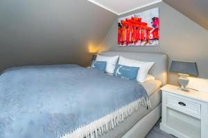 a bedroom with a bed with a blue comforter at Tolle Wohnung mit Sonnenbalkon in Wenningstedt
