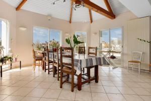 a dining room with a table and chairs and windows at Chambre d'hôtes à Saint-Molf in Saint-Molf