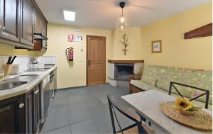 a kitchen and living room with a table and a couch at Puente del Narcea 3 in Cibuyo