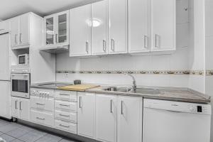 a white kitchen with white cabinets and a sink at Chipiona Centro y Playa in Chipiona