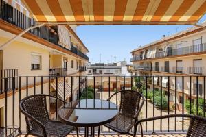 a patio with a table and chairs on a balcony at Chipiona Centro y Playa in Chipiona