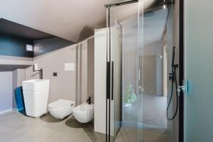 a bathroom with a toilet and a glass shower at Gc Luxury Apartments e Spa in Santa Margherita di Belice +50 photos