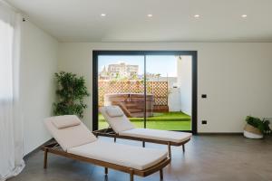 two chairs and a table in a room at Gc Luxury Apartments e Spa in Santa Margherita di Belice