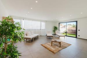 a living room with white furniture and plants at Gc Luxury Apartments e Spa in Santa Margherita di Belice