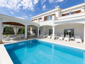 a villa with a swimming pool and a house at Villa Olivia by Interhome in Šestanovac