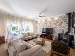a living room with a stone wall at Villa Olivia by Interhome in Šestanovac
