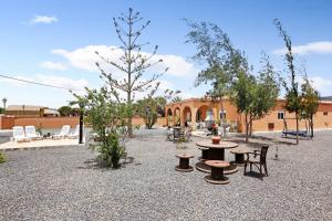 a courtyard with a table and chairs and a tree at Abundia House in Caleta De Fuste