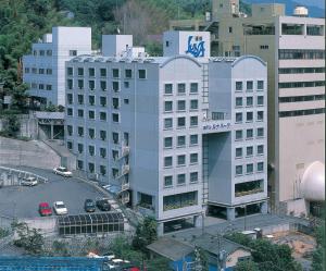 a large white building with a sign on it at Hotel Luna Park in Matsuyama