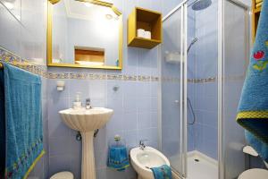 a blue tiled bathroom with a sink and a shower at Abundia House in Caleta De Fuste +30 photos