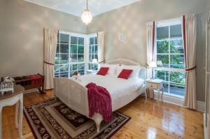 a bedroom with a white bed and two windows at Moulton Park Estate - Homestead in Sassafras