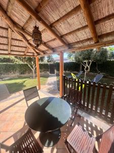 a patio with a table and chairs under a wooden pergola at Casas Pepe 6 Bungalow in Los Caños de Meca