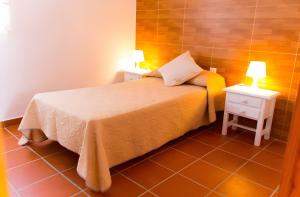 a bedroom with a bed with two night stands and two lamps at Casas Pepe 6 Bungalow in Los Caños de Meca