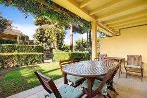 a wooden table and chairs on a patio at Chalet Cormoran in Chiclana de la Frontera