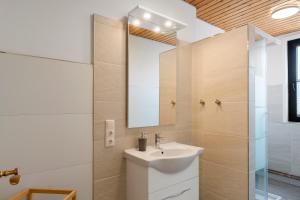 a bathroom with a sink and a mirror at Gästehaus Vogel in Horumersiel +98 photos