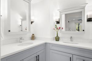 a white bathroom with two sinks and a mirror at 4826 Green Dolphin Way in Kiawah Island +39 photos