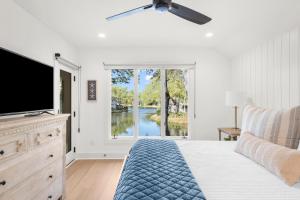 a bedroom with a bed and a tv and a window at 4826 Green Dolphin Way in Kiawah Island