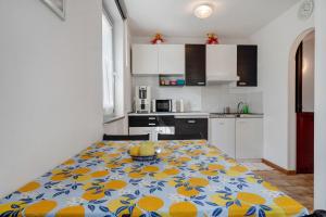 a kitchen with a table with a flower pattern on it at Ciclamino Standard Vittoria in San Lorenzo in Banale +28 photos