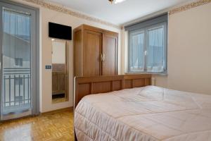 a bedroom with a bed and a flat screen tv at Ciclamino Standard Vittoria in San Lorenzo in Banale