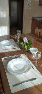 a wooden table with plates and wine glasses on it at Apartamentos Casa Ferrás in Valderrobres