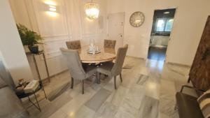 a dining room table with chairs and a clock on the wall at 240 Front line beach La Cala in La Cala de Mijas