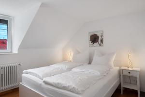 a white bed with white sheets and pillows at Ferienwohnung Alte Münz in Müllheim