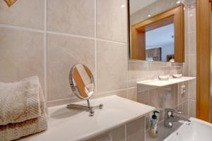 a bathroom with a mirror and a sink and a tub at Seeberg - Haus Annamirl in Bayrischzell +15 photos