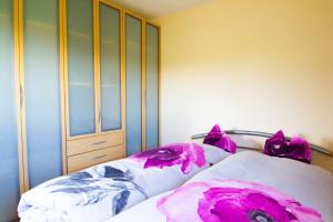 a bedroom with a bed with purple and white pillows at Klein aber Fein in Gottmadingen