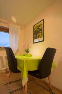 a green table and two chairs in a room at Klein aber Fein in Gottmadingen