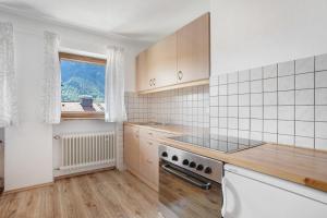 a kitchen with a stove top oven next to a window at Wohnung Hochstaufen in Inzell