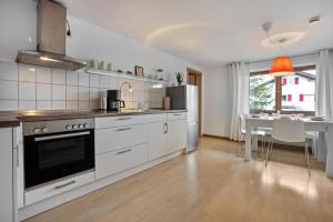 a kitchen with white appliances and a dining room at Ferienwohnung Silvia in Roßhaupten