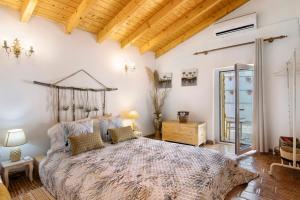 a bedroom with a large bed and a wooden ceiling at Quinta do Silêncio in Tavira +37 photos