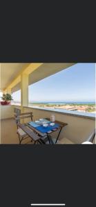 a table on a balcony with a view of the beach at Casa Vacanza Sa Petra Ruja B in Siniscola