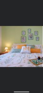 a bed in a bedroom with pictures on the wall at Casa Vacanza Sa Petra Ruja B in Siniscola