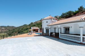 a white house with a patio and a swimming pool at Sunset El Tejar in Almogía