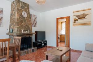 a living room with a fireplace and a couch at Sunset El Tejar in Almogía