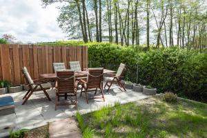 a patio with a wooden table and chairs at Haus Hein Mück in Norden