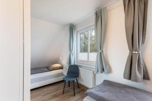 a bedroom with a window with a chair and a bed at Haus Hein Mück in Norden