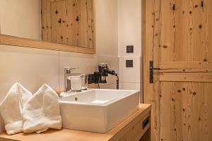 a bathroom with a white sink and a mirror at Hatzeshof Blumenwiese in Laion +14 photos