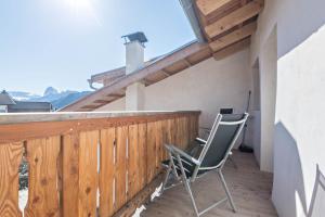 a balcony with two chairs and a wooden railing at Hatzeshof Blumenwiese in Laion