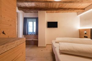 a room with two beds and a television on the wall at Hatzeshof Blumenwiese in Laion