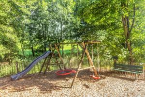 a playground with a swing set and a bench at Blockhaus 2 in Eslohe