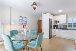 a dining room with a glass table and blue chairs at Puerto Playa 3 in Puerto del Rosario +13 photos