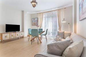 a living room with a couch and a table and chairs at Puerto Playa 3 in Puerto del Rosario