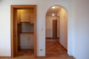 an open doorway to a kitchen with white cabinets at Apartment 4 - Zur Sonne in Laion