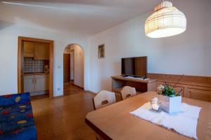 a living room with a wooden table and a television at Apartment 4 - Zur Sonne in Laion