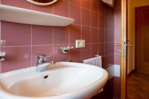 a bathroom with a white sink and pink tiles at Apartment 4 - Zur Sonne in Laion +17 photos